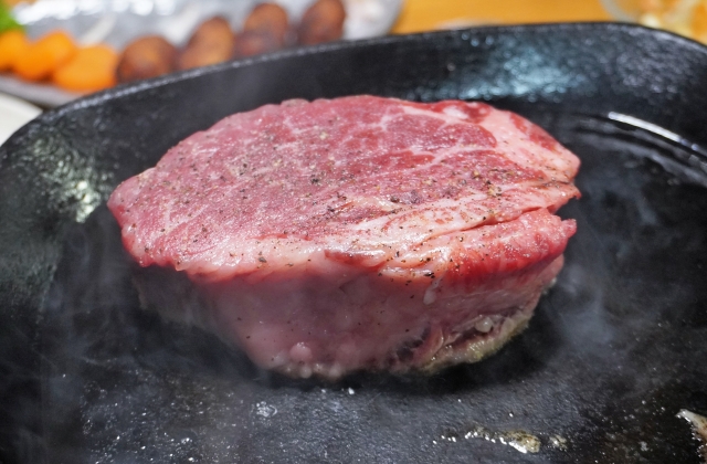 フライパンでステーキ肉を焼いているイメージ画像写真