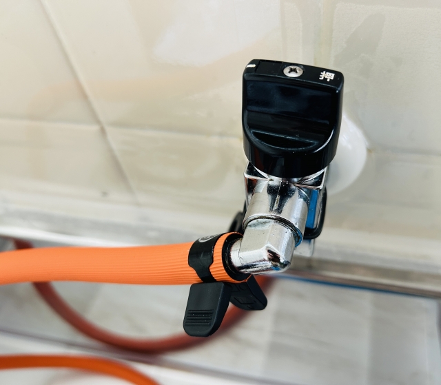 LPガス用のオレンジ色のゴムホースとガス栓のイメージ写真画像