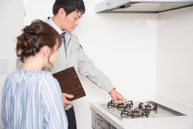 ガスコンロについて作業員が入居者に説明している、イメージ写真