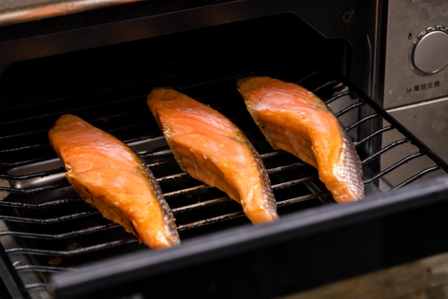 魚焼きグリルで鮭を焼いているイメージ写真
